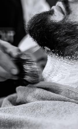 master shaving a client's beard